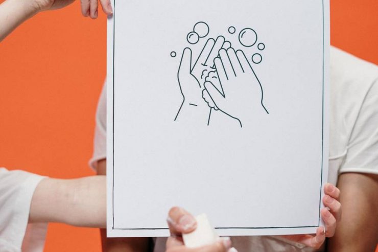 person holding a poster on proper hand washing