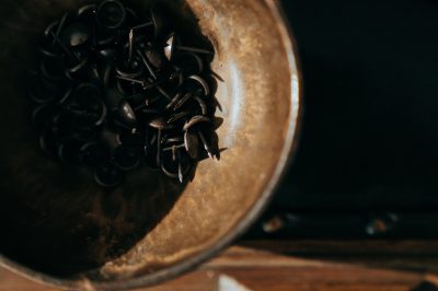 black coffee beans in brown round container